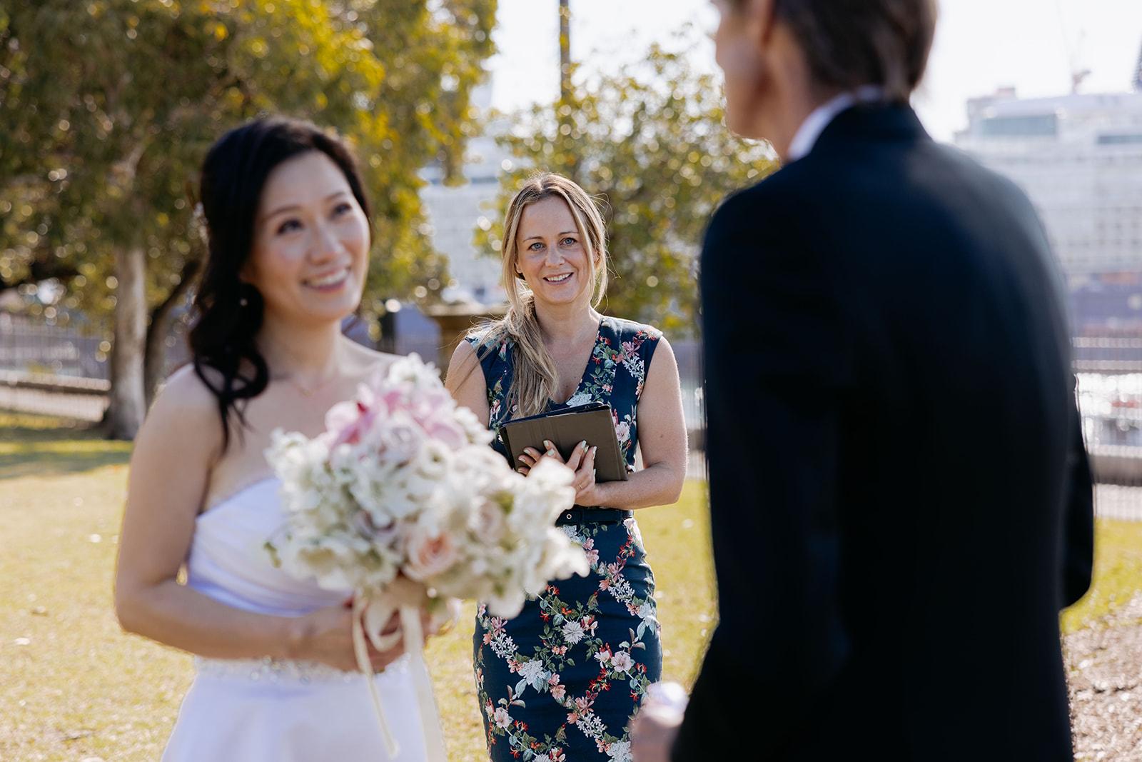 Wedding ceremony at Palm Beach, the couple under a floral arch.