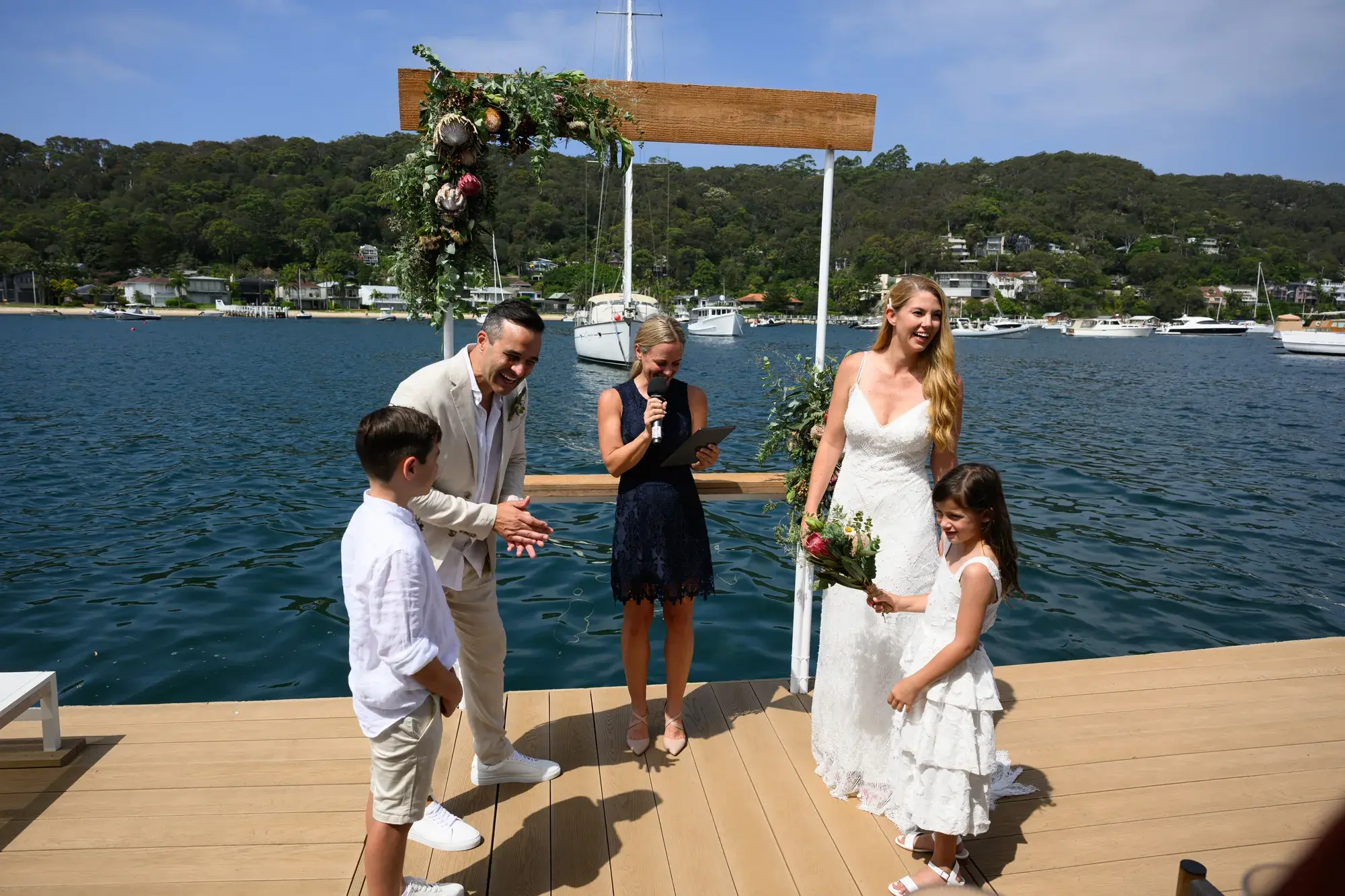 Beachside wedding ceremony, the couple mid-laugh.