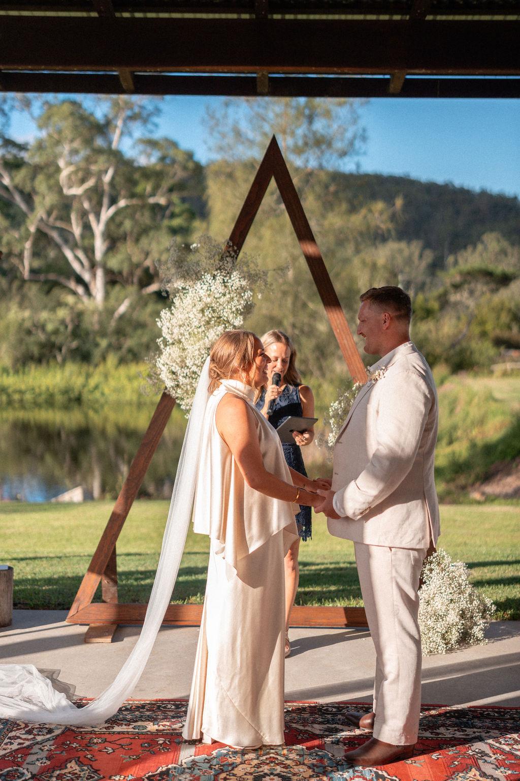 Coastal wedding ceremony, the couple sharing a first kiss.