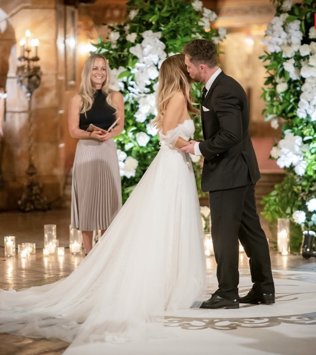 Celebrant reading vows beside a smiling couple
