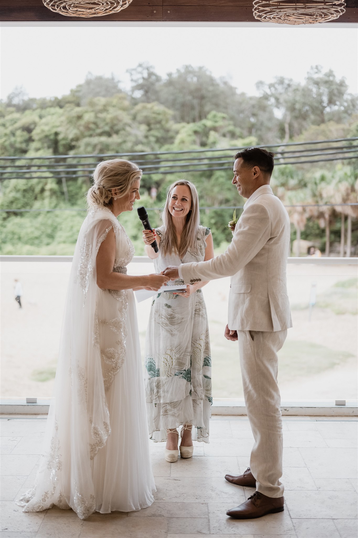 Sarah Emery at Shelly Beach Boathouse, in conversation with a couple before their ceremony